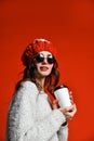 Close up portrait of a smiling young girl in hat holding take away coffee cup Royalty Free Stock Photo