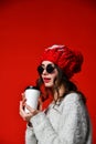 Close up portrait of a smiling young girl in hat holding take away coffee cup Royalty Free Stock Photo