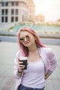 Close up portrait of a smiling young girl red hair style in hat holding take away coffee cup outdoors Royalty Free Stock Photo