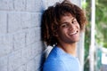 Close up portrait of smiling young man leaning against wall Royalty Free Stock Photo