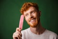 Close-up portrait of smiling young readhead beardy man with pink Royalty Free Stock Photo