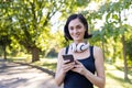 Close-up portrait of a smiling young woman doing sports in the park, going for a run, standing in headphones, holding a Royalty Free Stock Photo