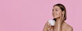 Close-up portrait of smiling young woman with straight hair using face skin care cream on her face, doing beauty routine after Royalty Free Stock Photo