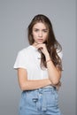 Close up portrait of smiling young woman in white t-shirt looking at camera on gray background Royalty Free Stock Photo