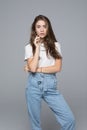 Close up portrait of smiling young woman in white t-shirt looking at camera on gray background Royalty Free Stock Photo