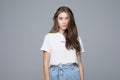 Portrait of smiling young woman in white t-shirt looking at camera, isolated on gray background Royalty Free Stock Photo