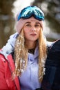 Close up portrait of snowboarder woman at ski resort wearing helmet and goggles with reflection of forest in mountains Royalty Free Stock Photo