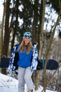 Close up portrait of snowboarder woman at ski resort wearing helmet and goggles with reflection of forest in mountains Royalty Free Stock Photo