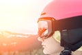 Close up portrait of snowboarder woman at ski resort wearing helmet and goggles with reflection of mountains. Sun flare Royalty Free Stock Photo