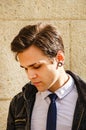 Close up portrait of stylish attractive young man standing against wall outside on sunny day Royalty Free Stock Photo
