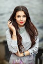 Close-up portrait of a stylish and very beautiful brunette girl, red lipstick, street style Royalty Free Stock Photo