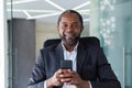 Close-up portrait of successful businessman inside office, African American man smiling and looking at camera, satisfied Royalty Free Stock Photo
