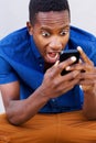 Surprised african man looking at his mobile phone and screaming Royalty Free Stock Photo