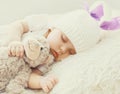 Close up portrait of sweet baby sleeping with teddy bear toy on a white bed Royalty Free Stock Photo