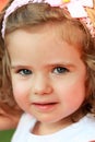 Close up portrait of a sweet one year old girl with pink head band and a bow, looking straight into the eyes Royalty Free Stock Photo