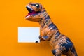 Close up and portrait of a t-rex holding a white paper to write your text here - dinosaur holding a copy space