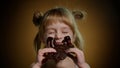 Portrait of teen smiling child kid girl smears face with melted chocolate and showing thumbs up sign Royalty Free Stock Photo