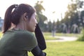 Side face of a young woman sitting in a park. Royalty Free Stock Photo