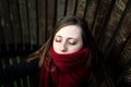 Close-up portrait of a thirty year old attractive white girl wearing a red winter scarf, eyes closed Royalty Free Stock Photo