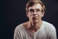 Close-up portrait of thoughtful frowning student in glasses