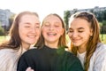 Close-up portrait, three girls schoolgirls teenagers, summer outdoors. Happy smiling play, Photography phone, selfie