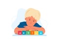 Close up portrait of toddler autistic boy with word AUTISM on wooden blocks