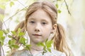 Close-up portrait of a toddler girl with red hair in front of a cherry blossom. Spring Royalty Free Stock Photo