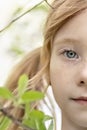 Close-up portrait of a toddler girl with red hair in front of a cherry blossom. Spring Royalty Free Stock Photo