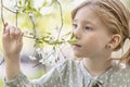 Close-up portrait of a toddler girl with red hair in front of a cherry blossom. Spring Royalty Free Stock Photo