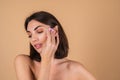 Close up portrait of a topless woman with bare shoulders on a beige background Royalty Free Stock Photo