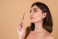 Close up portrait of a topless woman with bare shoulders on a beige background Royalty Free Stock Photo
