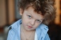 Close-up portrait of tough funny boy child sitting in stylish shirt