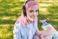 Close up portrait of trendy hipster Caucasian beautiful young woman with pink hair in headphones listening to music Royalty Free Stock Photo