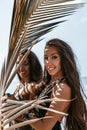 Close up portrait of two beautiful twin woman sisters on the beach