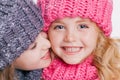 Close-up portrait of two cute little sisters in winter clothes. Pink and grey hats and scarfs. Family Royalty Free Stock Photo