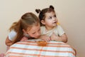 Close up portrait of two funny cute little girl eat honey in home. Royalty Free Stock Photo