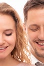 Close up portrait of two halves of face a positive smiling man and woman with closed eyes on white background. Halfface