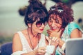 Two happy senior women laughing and having fun while drinking coffee in a outdoor cafe Royalty Free Stock Photo