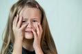 Close-up portrait of unhappy little girl with long hair covering her face with hands crying Royalty Free Stock Photo