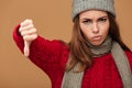 Close-up portrait of upset woman in winter clothes showing thumb Royalty Free Stock Photo