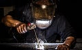 Close up portrait view of professional mask protected welder man welding metal and sparks metal Royalty Free Stock Photo