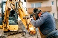 Portrait of welder working on excavator on construction site, reparing and fixing Royalty Free Stock Photo