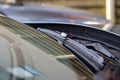 A close up portrait of a windshield wiper of a car standing at its lowest of base position. The blade is resting on the glass of Royalty Free Stock Photo