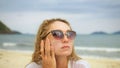 Close-up portrait woman apply sun cream protection lotion. Young woman on beach near sea applying sunscreen. Pretty Royalty Free Stock Photo