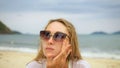 Close-up portrait woman apply sun cream protection lotion. Young woman on beach near sea applying sunscreen. Pretty Royalty Free Stock Photo