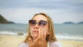 Close-up portrait woman apply sun cream protection lotion. Young woman on beach near sea applying sunscreen. Pretty Royalty Free Stock Photo