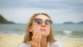 Close-up portrait woman apply sun cream protection lotion. Young woman on beach near sea applying sunscreen. Pretty Royalty Free Stock Photo