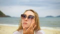Close-up portrait woman apply sun cream protection lotion. Young woman on beach near sea applying sunscreen. Pretty Royalty Free Stock Photo