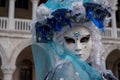 Close up portrait of woman in beautiful blue costume, hat and mask at the Doges Palace, Venice, during the carnival