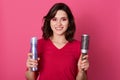 Close up portrait of woman being ready for combing her hair, holding hair styling spray and comb in hands, looking at camera. Royalty Free Stock Photo